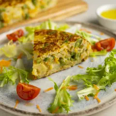 Pyszny omlet z piekarnika z warzywami, podany z sałatką i pomidorkami.